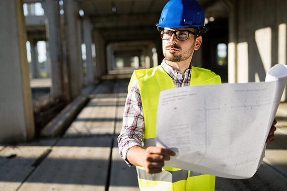 Engineers working on a building site Engineers working on a building site holding a blue prints